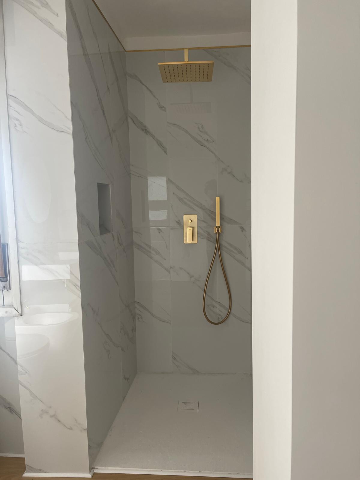 Doccia in marmo con finiture oro